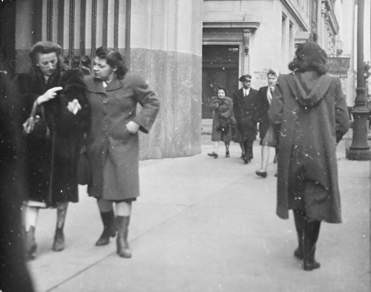 Street Scene. Two Women talking and a Woman passing by