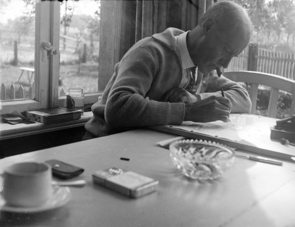Lyonel Feininger zeichnend an seinem Tisch auf der Veranda (L. Feininger bei der Arbeit*)