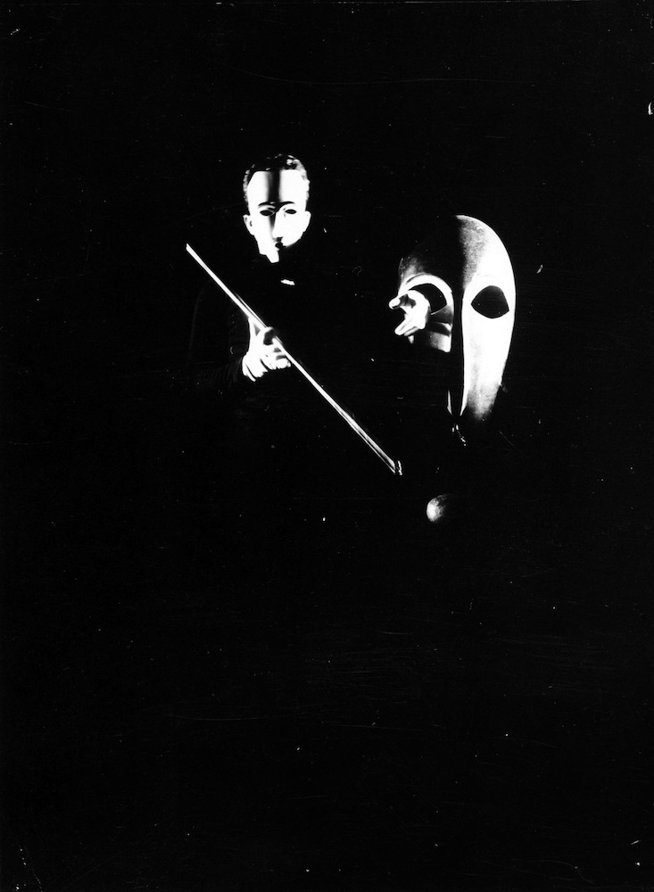 Mask-Scene II. Werner Siedhoff posing with two masks by T. Lux Feininger