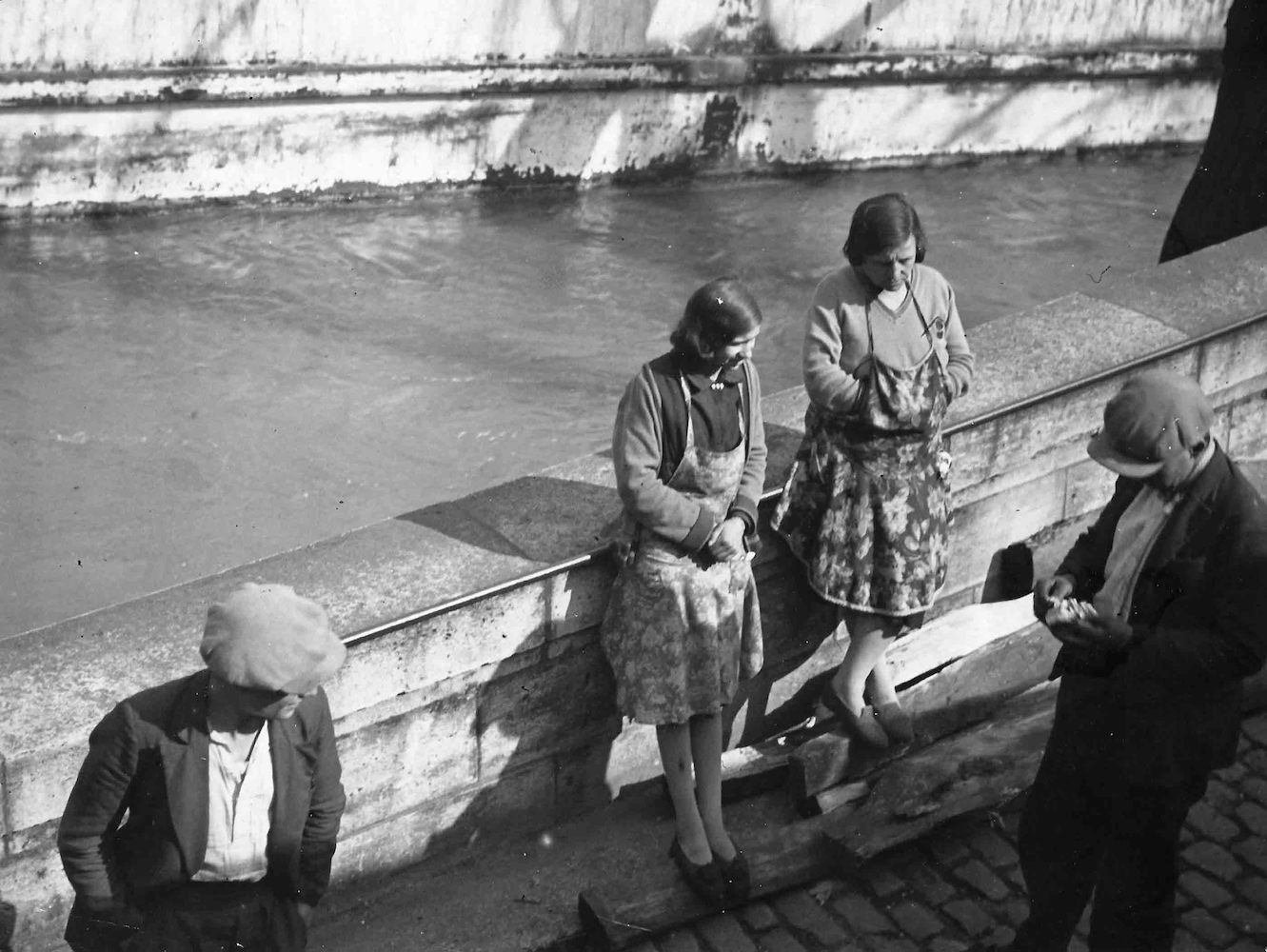Street Scene in Paris. Group of two Men and two Women on the Embankment of the Seine