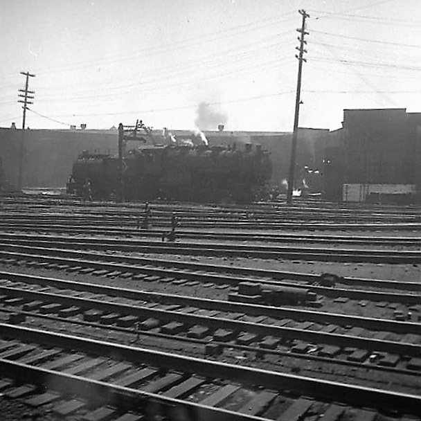 Blick aus einem Zug auf Gleise mit abdampfender Lok I