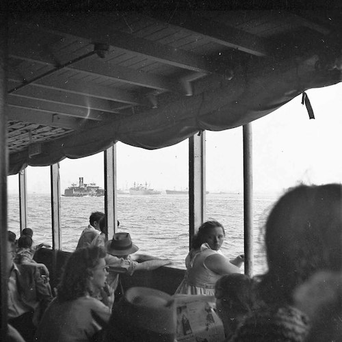 An Bord der Staten Island-Fähre. Blick auf eine New York Central R.R. Fähre und aufgelegte Victory Ships