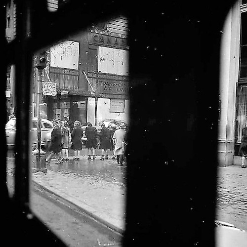 Rainy Day. Pedestrians at the Curb, photographed from inside a Bus, 