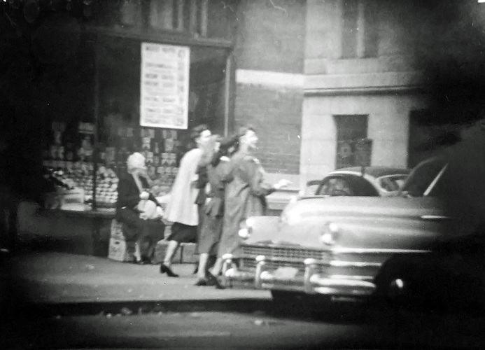 Straßenszene. Vier junge Frauen und eine ältere Frau vor einem Schaufenster [Telefoto]