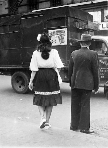 Straßenszene. Junge Frau und Mann mit Hut am Straßenrand vor einem Express-Lieferwagen
