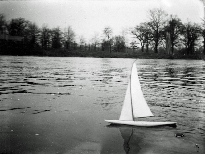 Modellyacht mit gebogenem Mast, auf der Mulde segelnd