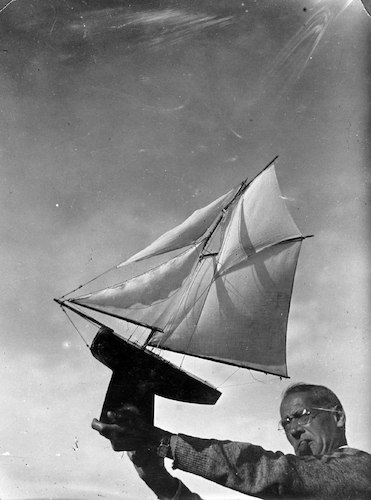 Lyonel Feininger hält eine Modellyacht in den Wind