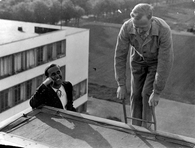 Erklettern des Schutzdachs auf dem Bauhaus. Hans Bertolf und Eddie Collein