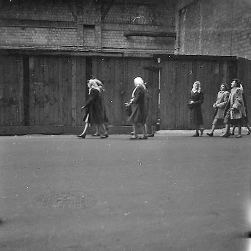 Street Scene. Cheerful women in front of a Shed (Four Women Walking, very Black Background)
