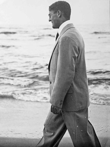 Laurence Feininger im Anzug beim Strandspaziergang
