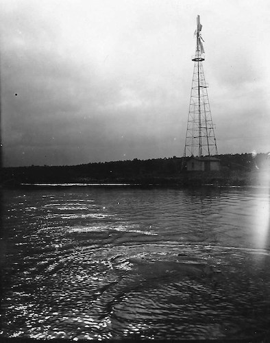 Am Wasser mit einer Windmühle im Hintergrund
