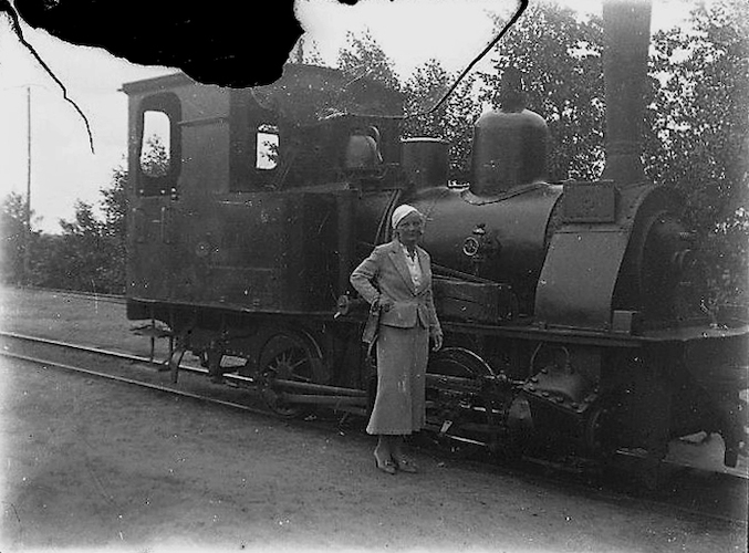 Junge Frau vor einer Lokomotive der Treptower Kleinbahn