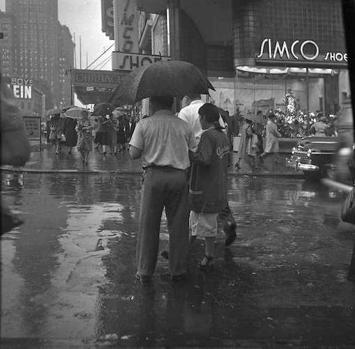 Rainy Day. Couple with Umbrella on the Street in front of 