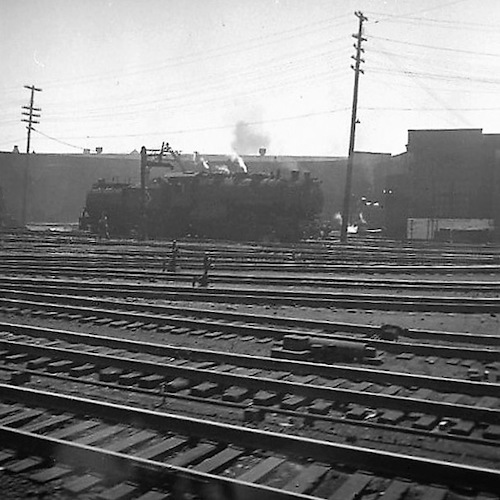 Blick aus einem Zug auf Gleise mit abdampfender Lok I