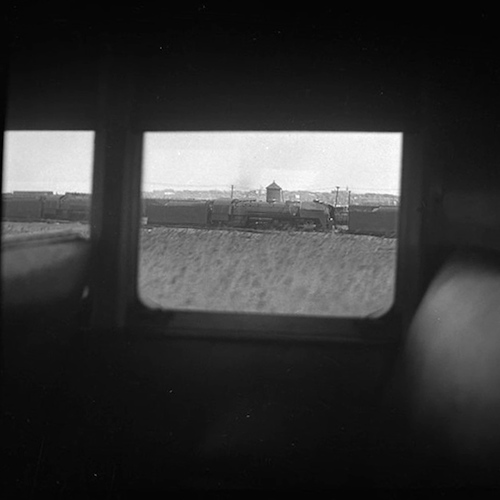 Blick aus einem Zug auf ein Güterzug vor einem Wassertank