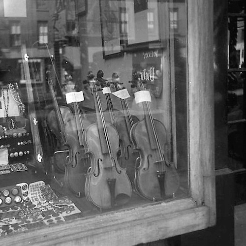 Spiegelung in einem Schaufenster mit Geigen