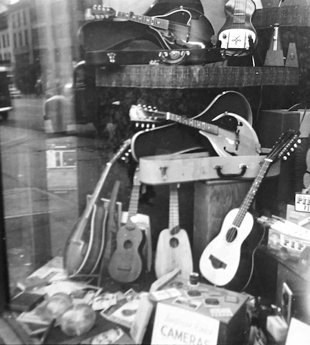 Spiegelung in einem Schaufenster mit Guitarren
