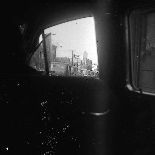 View of parked Cars, photographed from the Back Seat of a Car