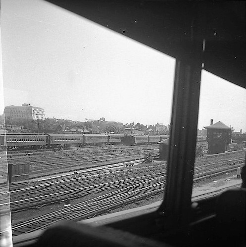 Blick aus einem Zug auf eine große Gleisanlage mit Personenzügen